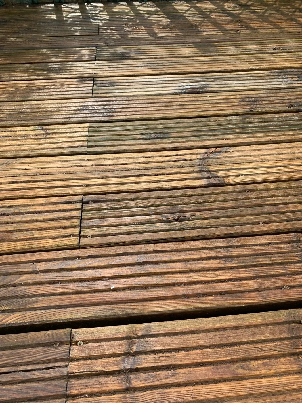 Timber garden decking part-cleaned