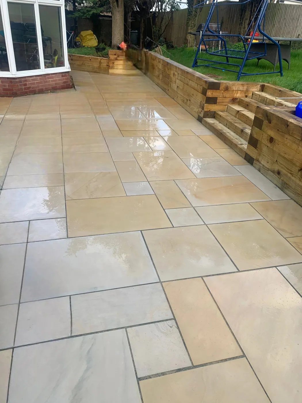 Wet, freshly cleaned Indian sandstone patio slabs